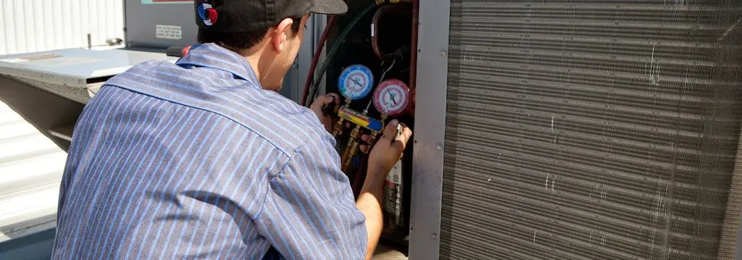 HVAC technician servicing a condenser unit in Chesterton